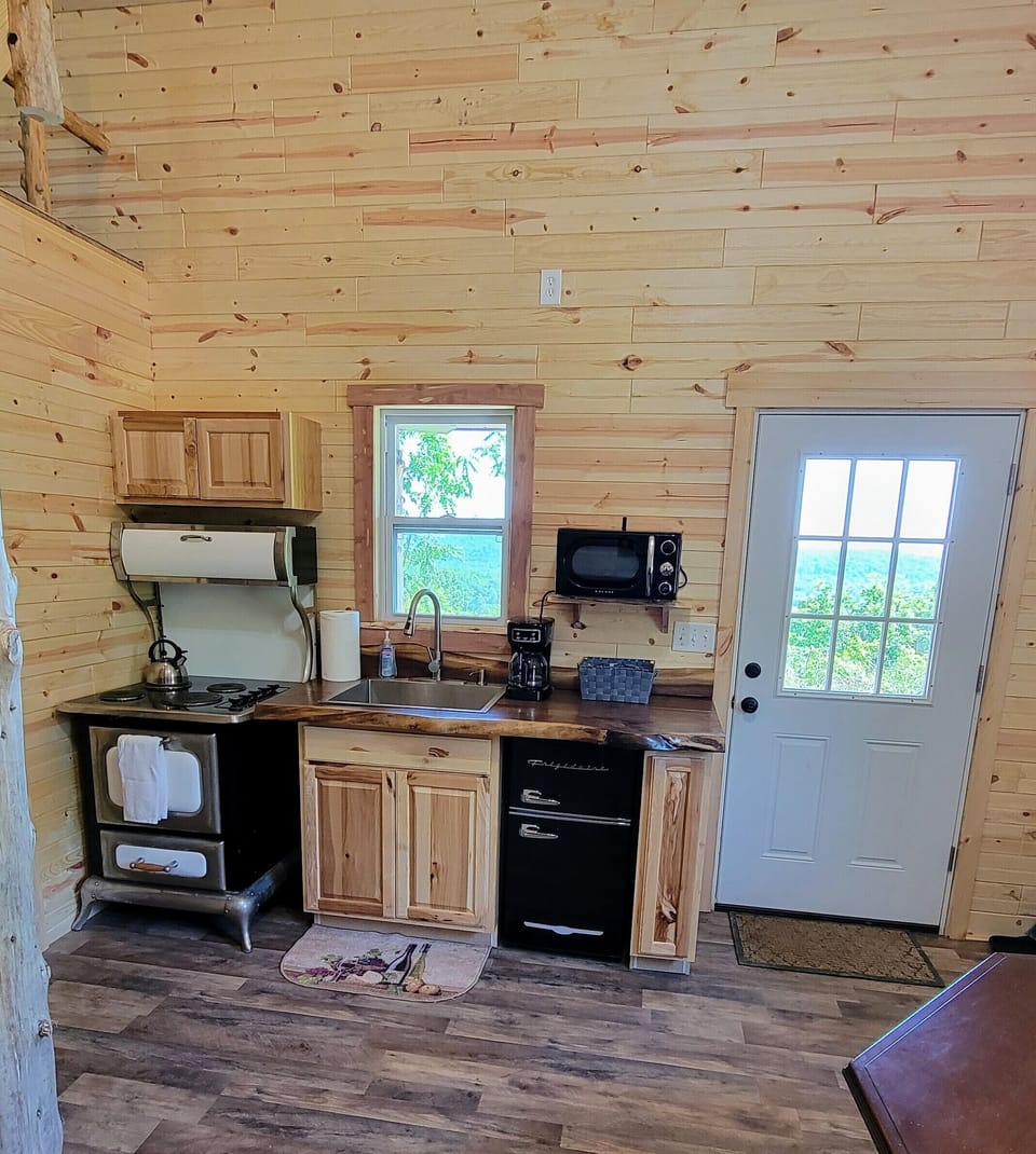 Kitchen with tea kettle, coffeemaker, microwave, mini fridge/freezer, and oven