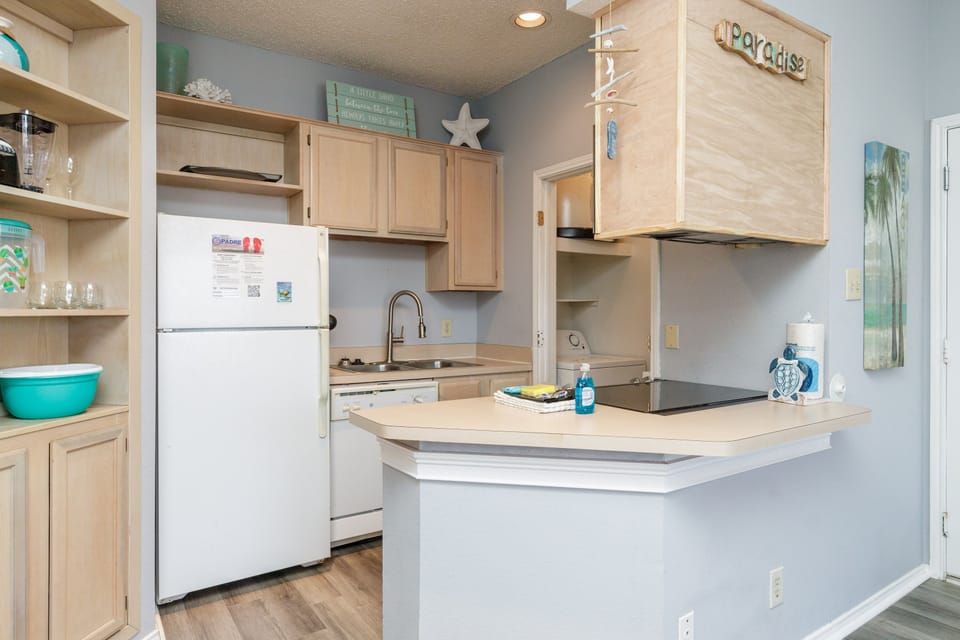 Cook your favorite meals in this bright, fully equipped kitchen with modern appliances and beach-themed touches.