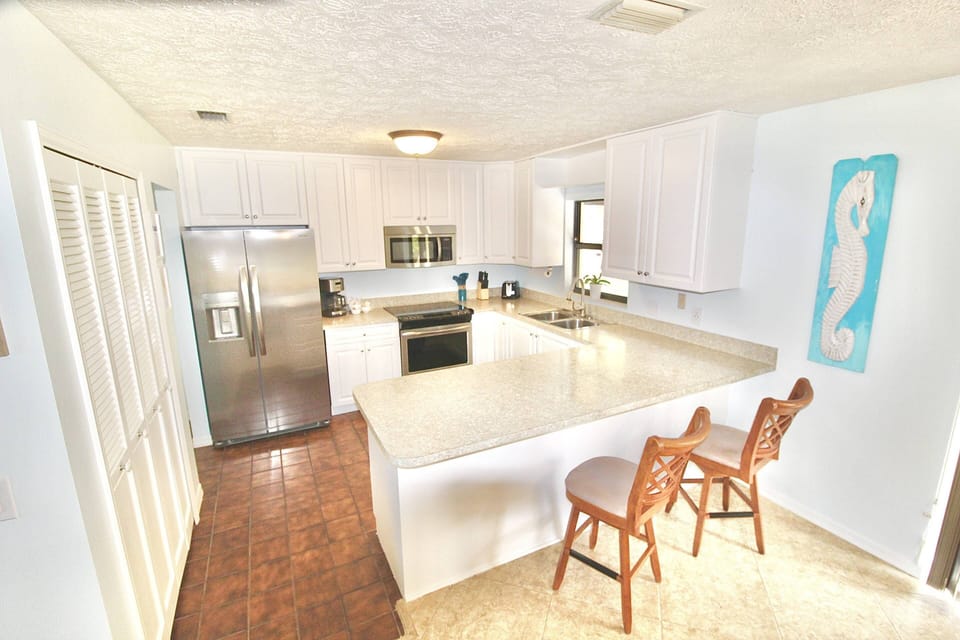 The bright, beautiful kitchen of Sandpiper Stay is fully stocked with all you need to cook and dine.