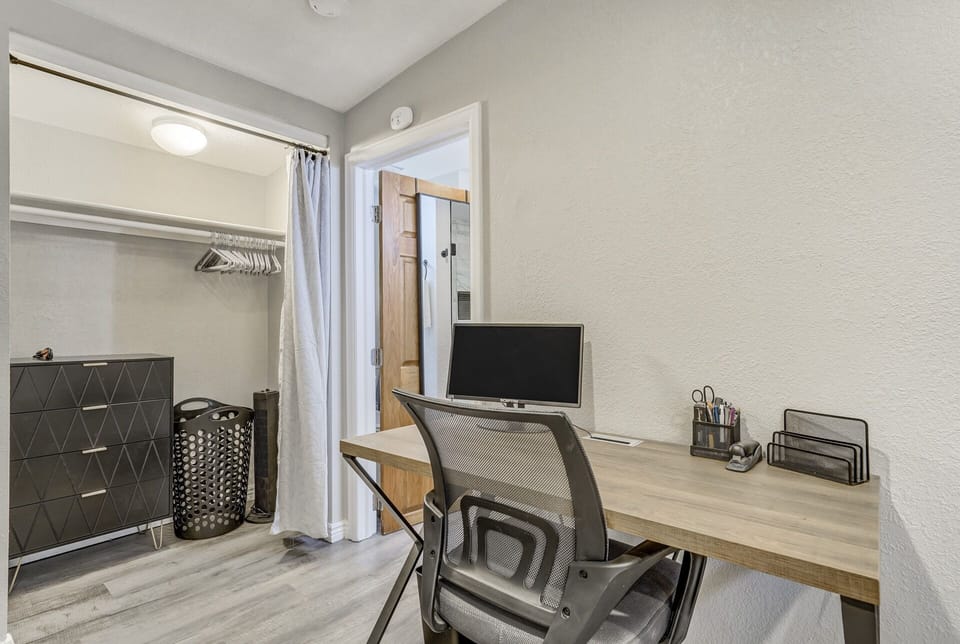 Bedroom with a queen sized bed, desk and a washer and dryer!