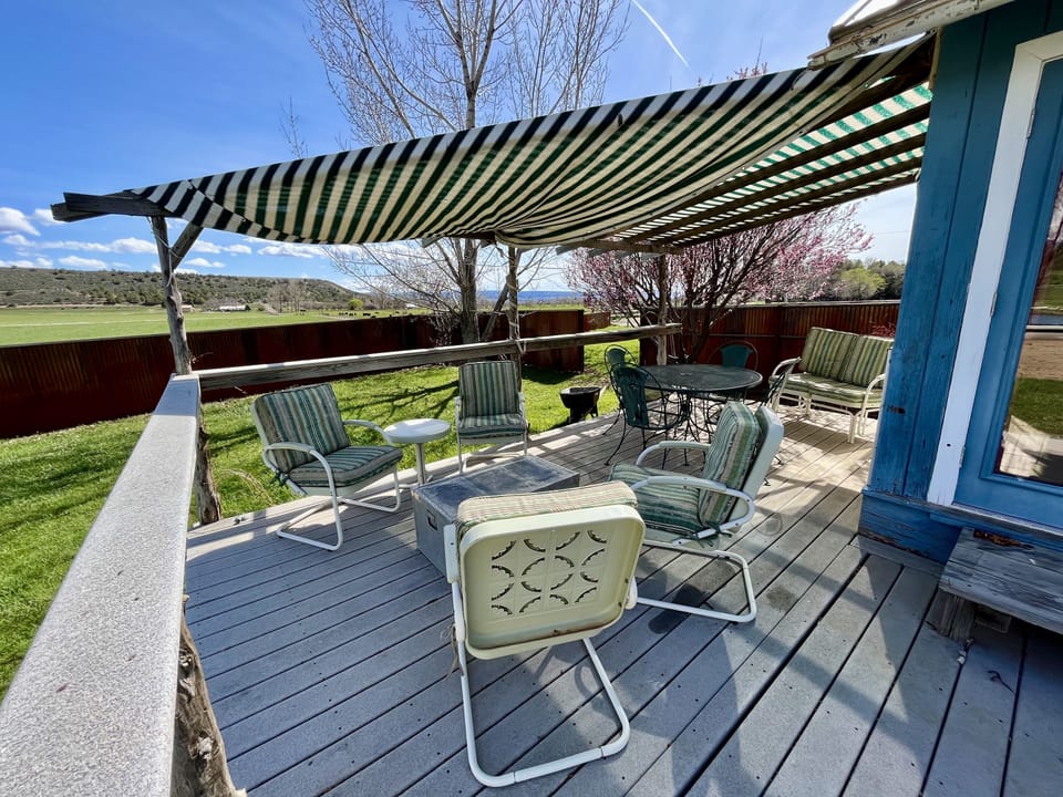 Back porch off the living room with lots of comfortable seating and views.