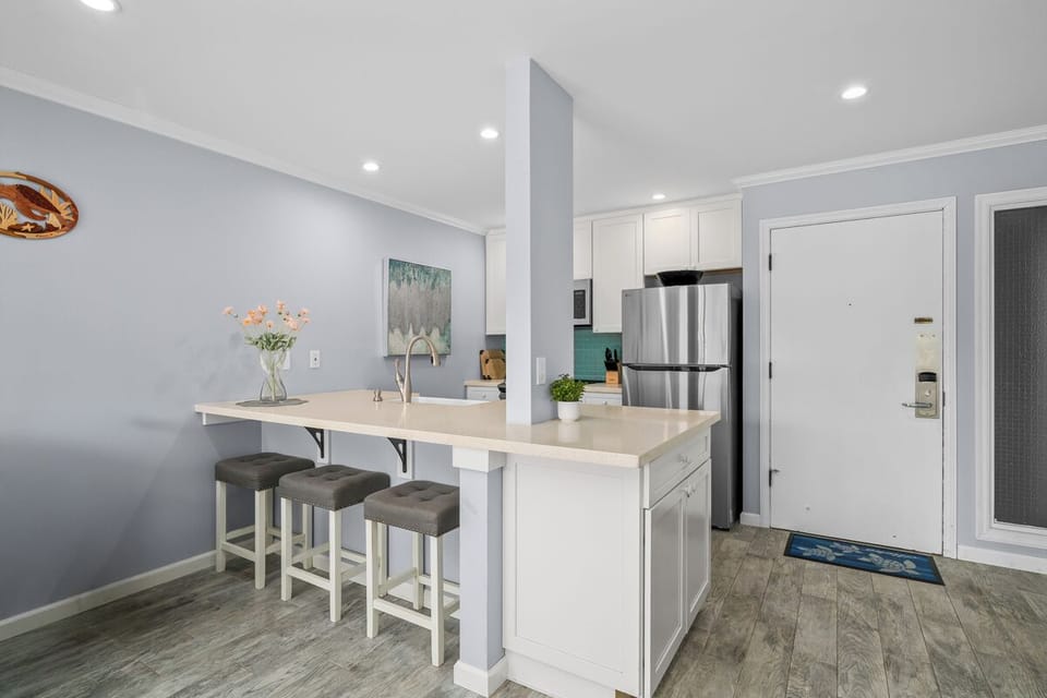 Step into your bright, modern kitchen featuring sleek stainless appliances, a breakfast bar with cozy seating, and fresh touches perfect for whipping up morning coffee or evening meals.