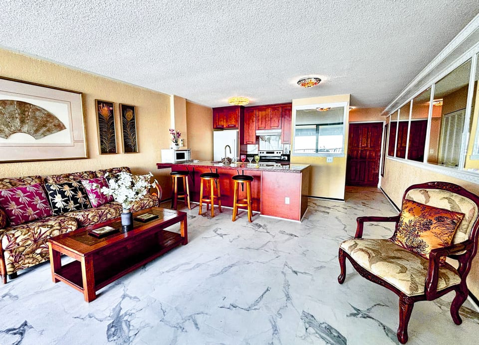 Beautiful living area and kitchen onlooking an expansive blue ocean