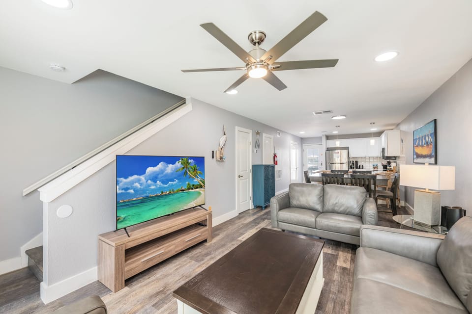 Relax in your modern living space with plush gray seating and open kitchen design for seamless entertaining.
