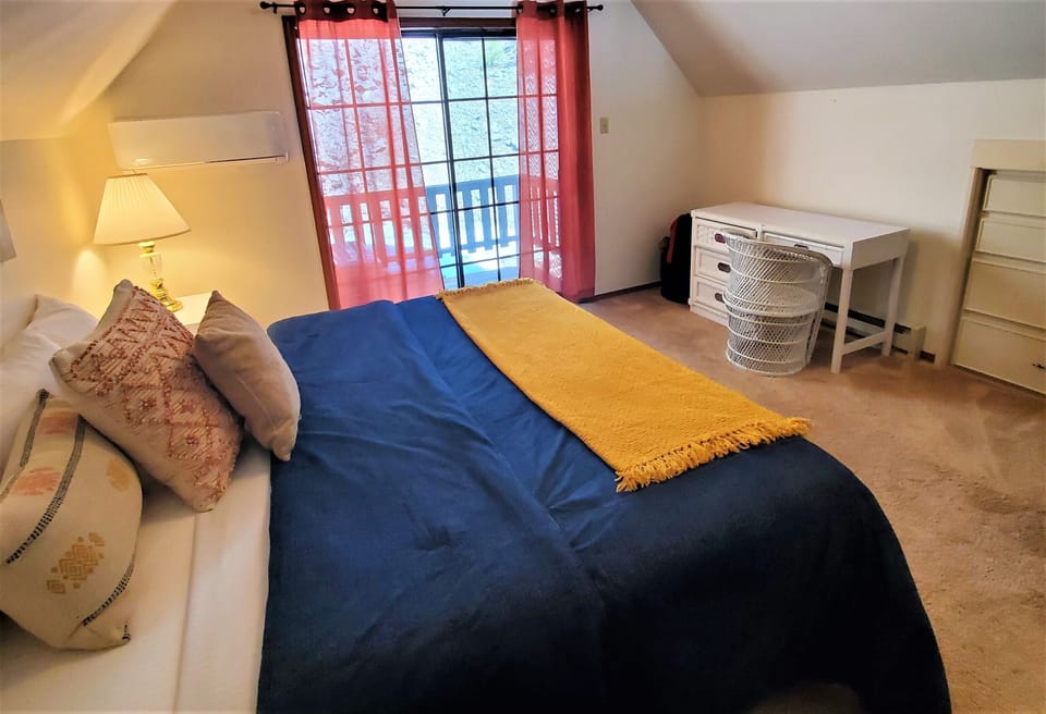Your cozy bedroom retreat awaits with a plush bed, bright natural light, and a desk for work or planning your next adventure.