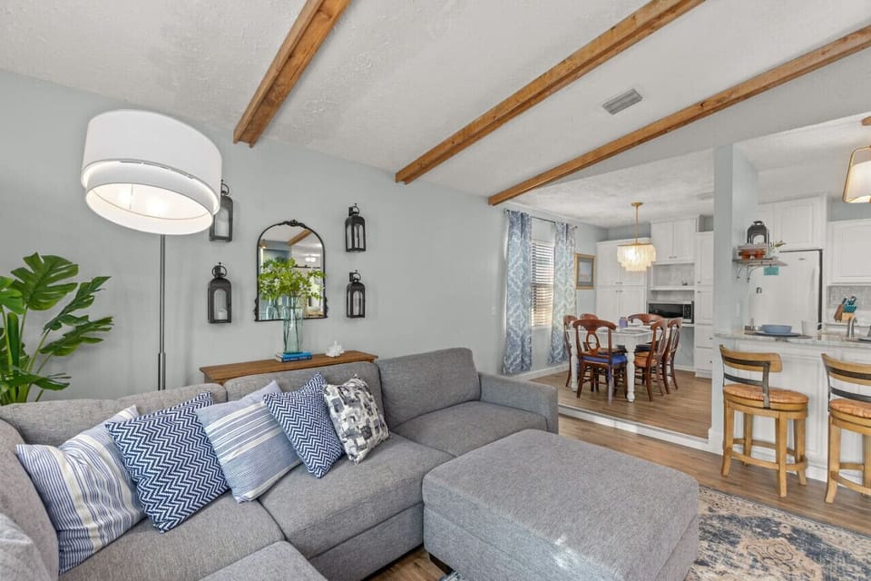 Stunning living room with exposed beams, boho-beach chic decor, smart TV, and so much more!