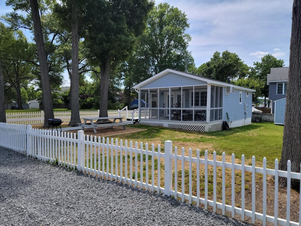 Fenced yard and outdoor picnic table and grill.  