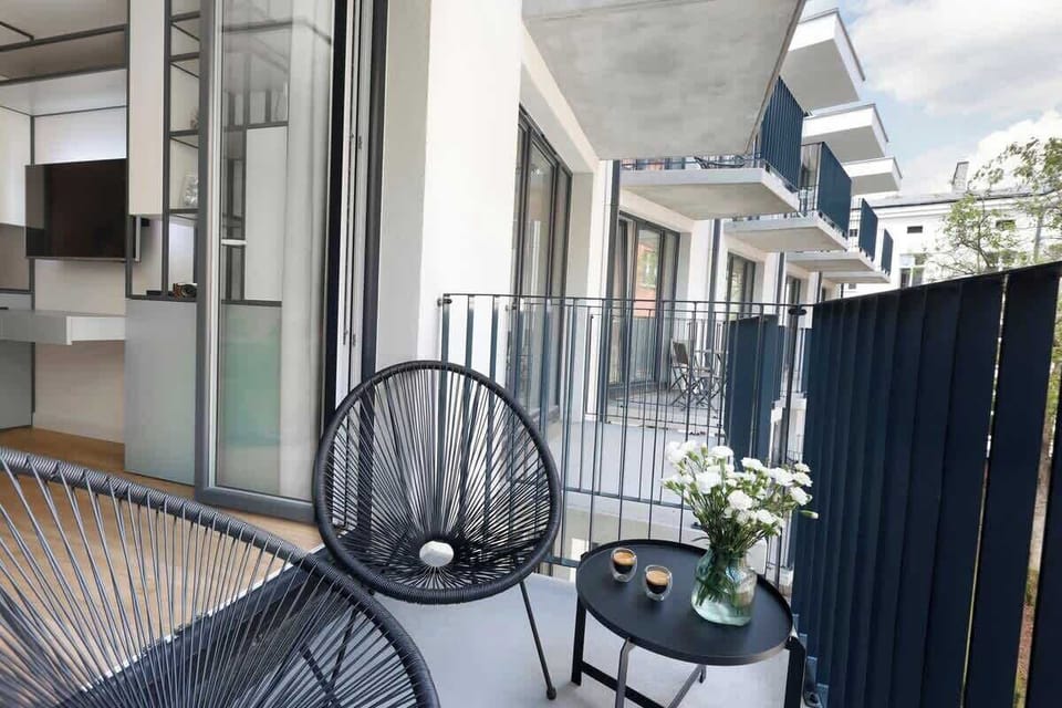 Spacious balcony with outdoor furniture. 