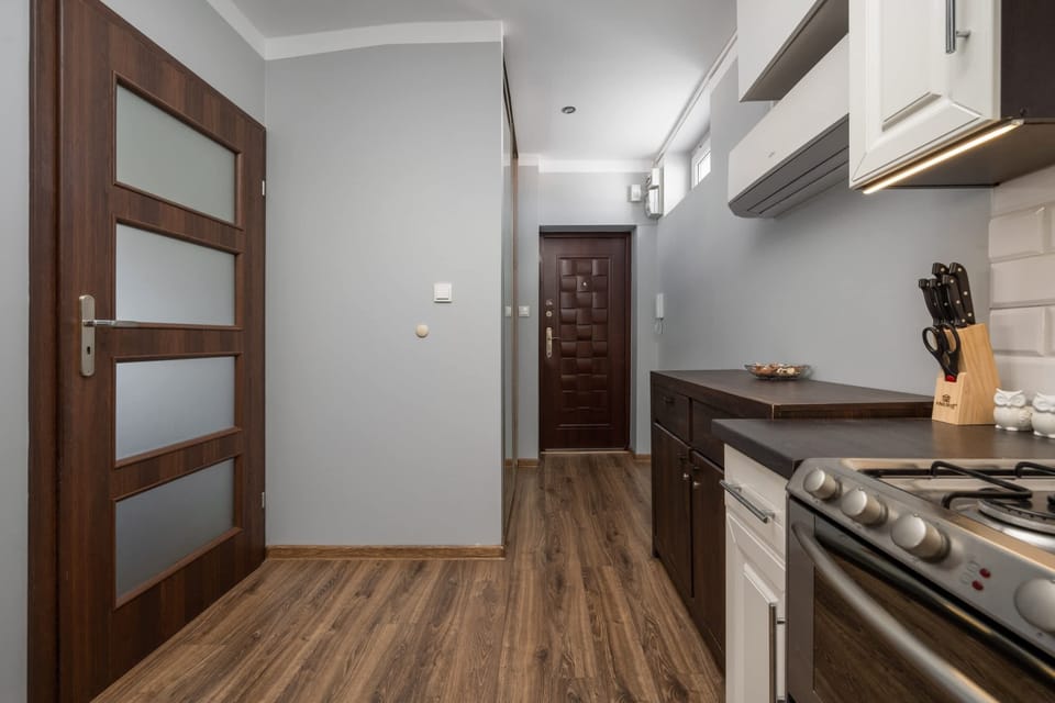 Another view of the kitchen, showing cabinets, appliances, and an elegant wood countertop.