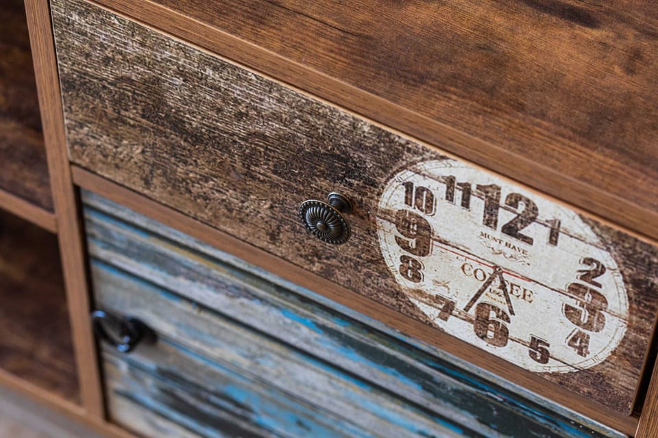 A close-up of a rustic clock face with Roman numerals. The weathered wood adds a vintage feel.