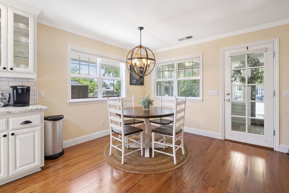 A round table beneath a sculptural pendant light brightens the nook