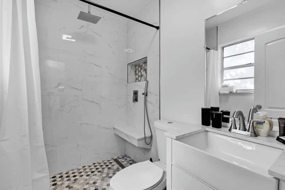 “Sleek bathroom with rainfall shower and fresh essentials—your Airbnb stay made relaxing and convenient.”