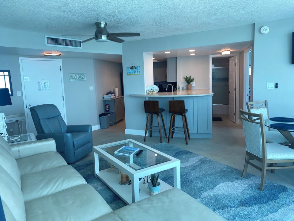 Living area with open kitchen and extra seating at breakfast bar.