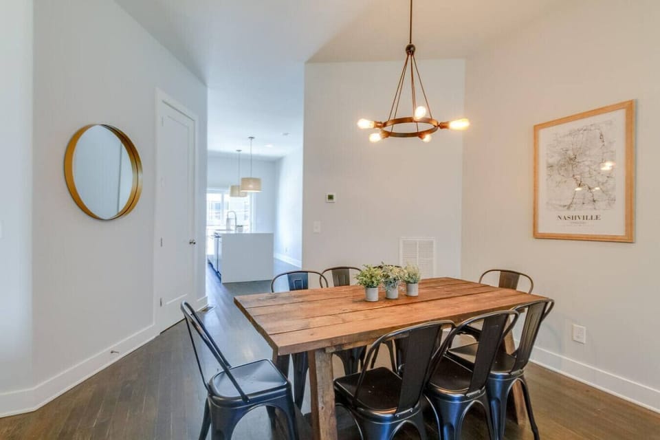 Elegant dining room with a wood table, chandelier, and decorative round mirror