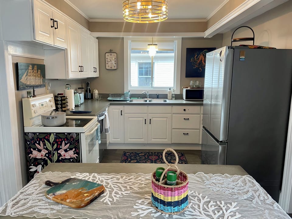 Kitchen has new large window for bright light and a breeze.