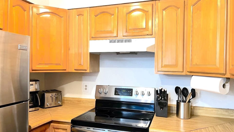 Kitchen has a coffee pot, toaster, kettle, dish washer and garbage disposal
