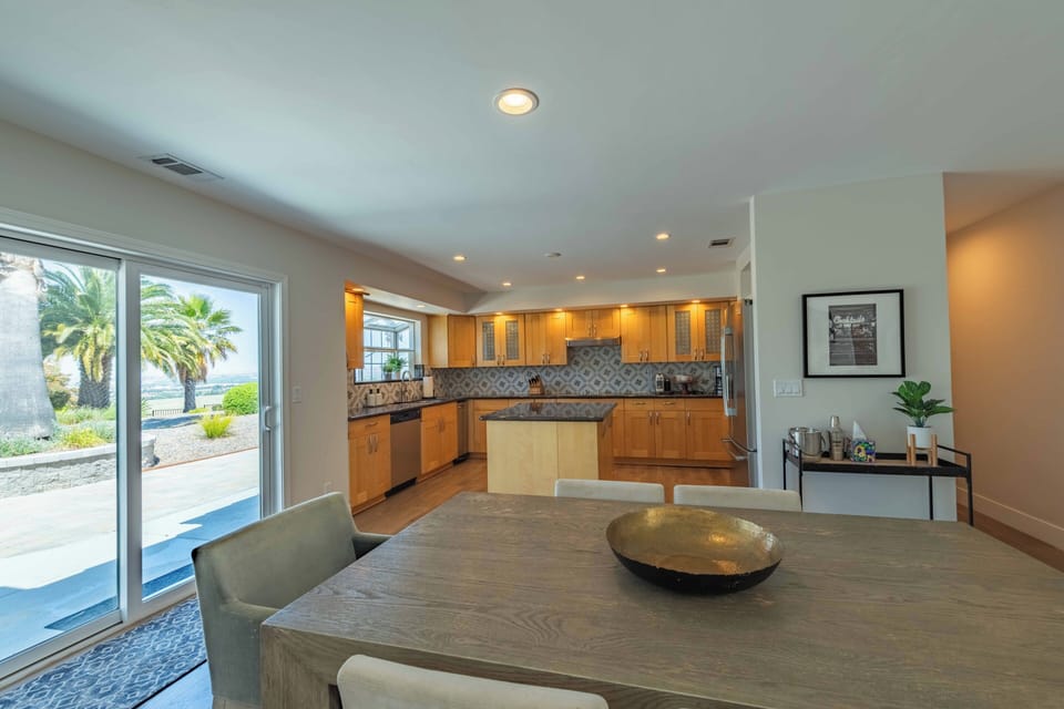 Gather around this spacious dining table that flows into your fully-equipped kitchen, where meals become moments. Step outside to palms swaying in the breeze.