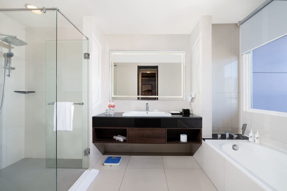 Suite, 1 King Bed, City View | Bathroom | Rainfall showerhead, free toiletries, hair dryer, slippers