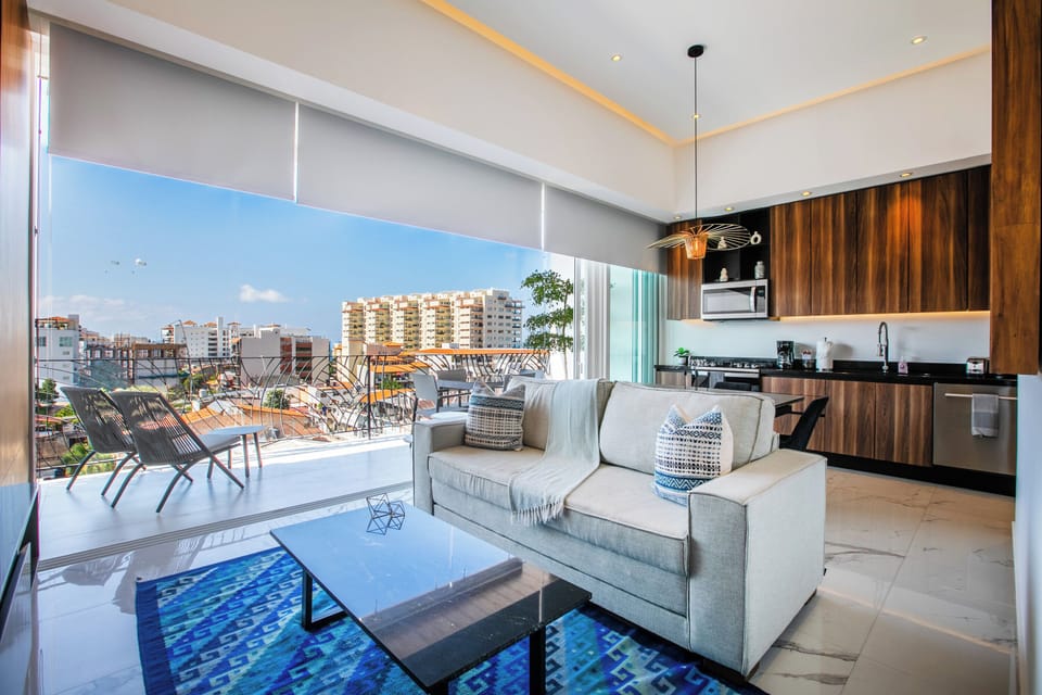 Sink into plush seating while enjoying your private city views through floor-to-ceiling windows in this bright, modern space.