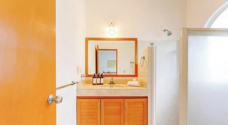 Bright bathroom with wooden cabinetry and a walk-in shower