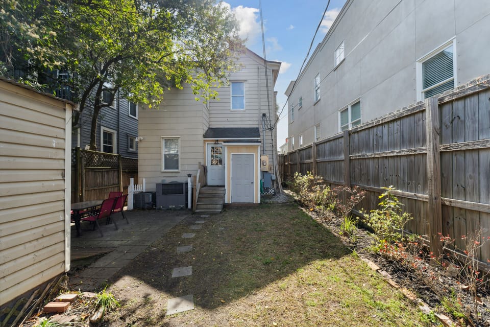 The backyard has a privacy fence and a patio furnished with a table and chairs.