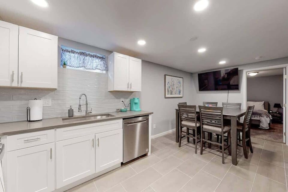 White cabinets and updated kitchen with stainless appliances make this basement feel spacious and bright.  Equipped with cooking amenities, Keurig Coffee maker with coffee pods provided. Dining table with 6 chairs and smart TV