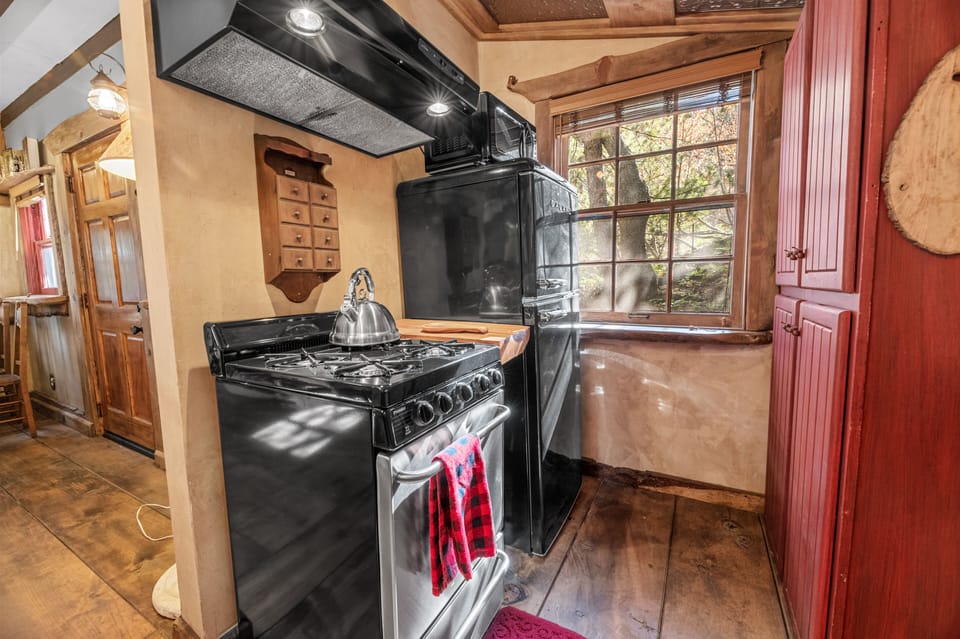 Full kitchen with gas range, oven, refrigerator and peaceful forest views