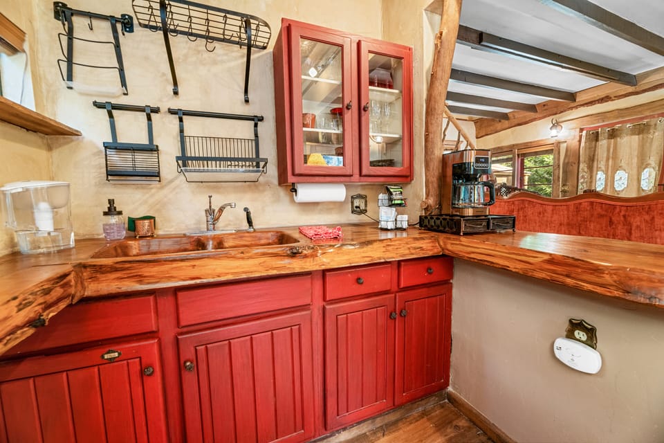 Well-stocked kitchen with cookware, dishes, glassware and coffee essentials