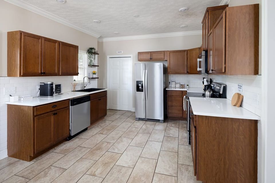Well-equipped kitchen with a window overlooking the backyard, bright cook space