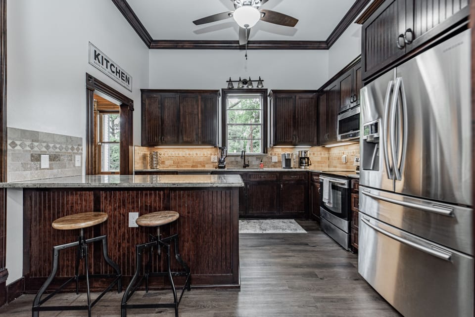 Kitchen with plenty of dishes, large fridge, and island, and pantry.