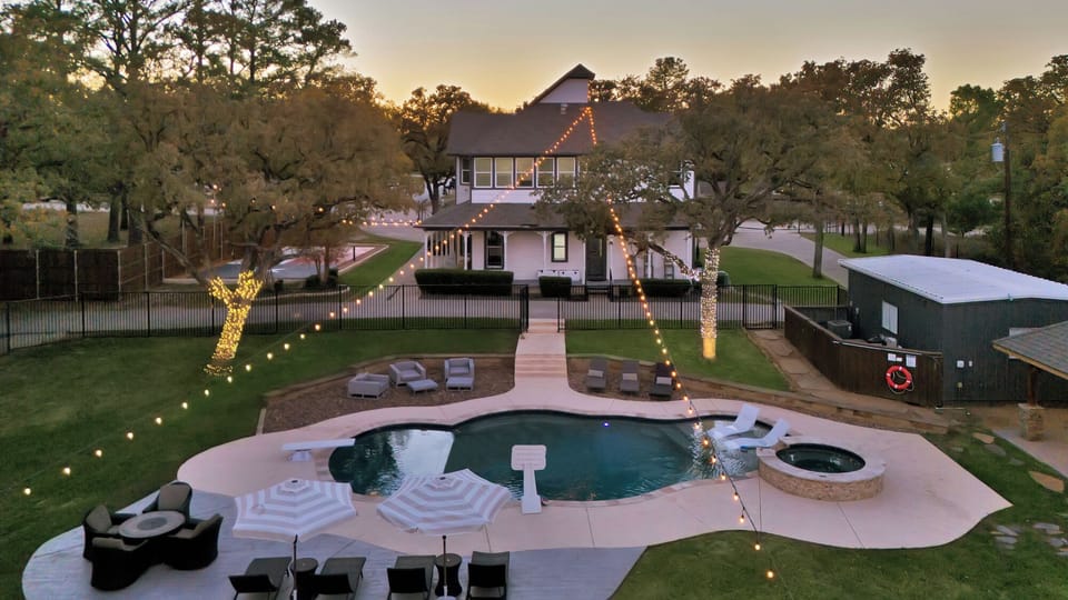 Arial view of the backyard and pool at dusk.