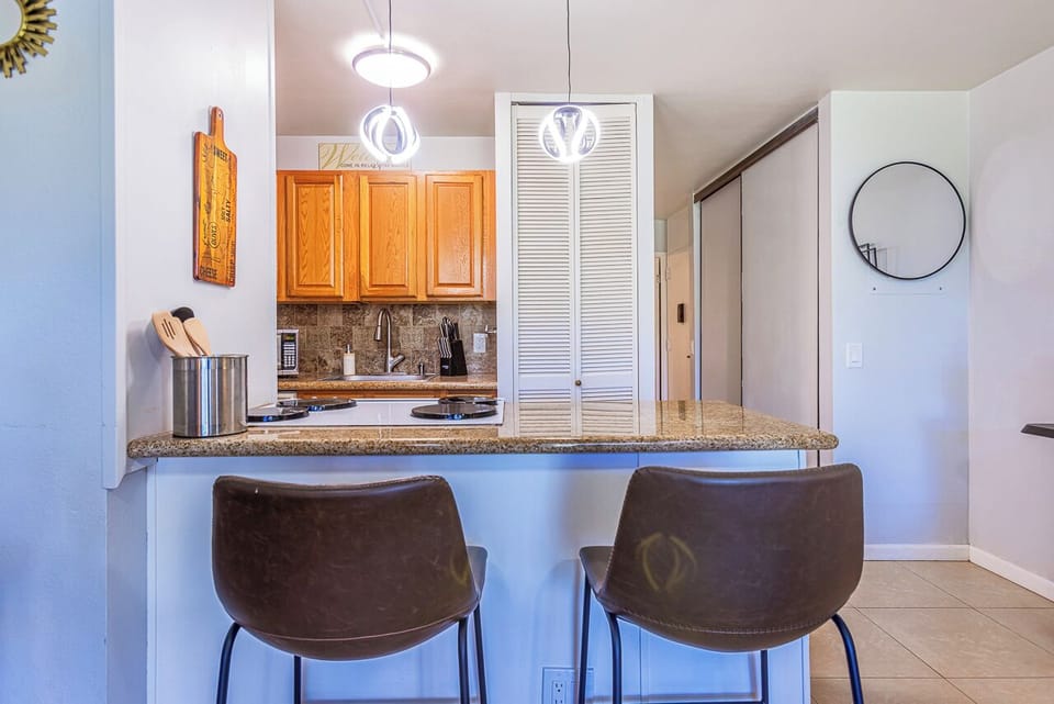 Gather at the breakfast bar where morning coffee and easy conversation come naturally. This bright kitchen nook invites you to start your day in relaxed comfort.