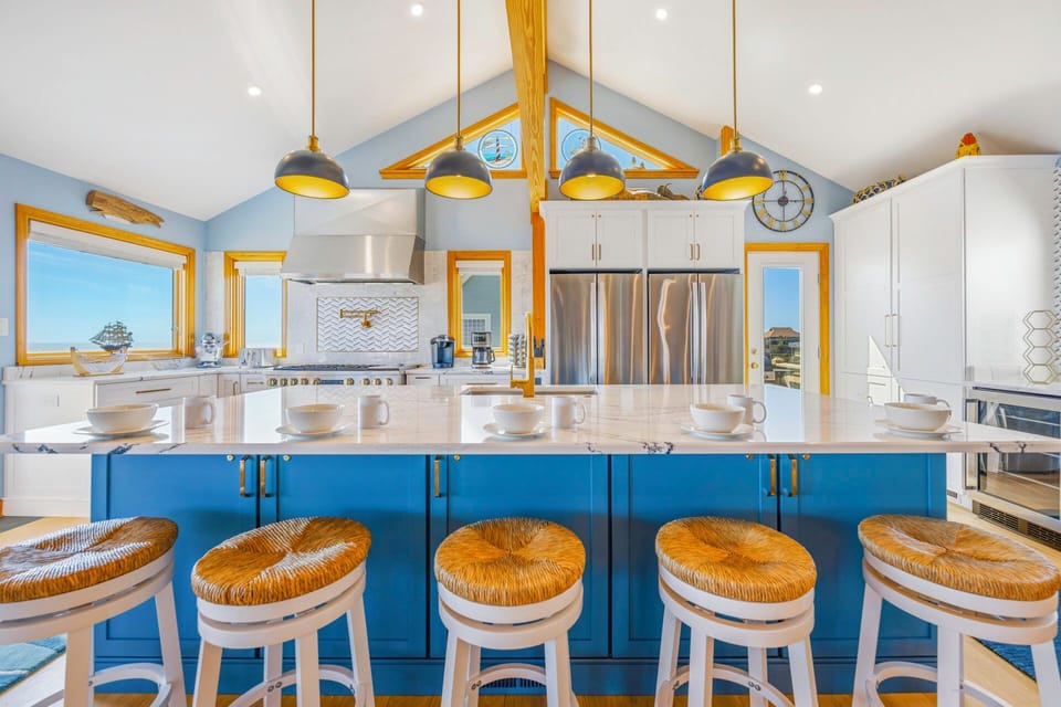 Your bright kitchen features a stunning blue island with counter seating, perfect for morning coffee or casual meals together.