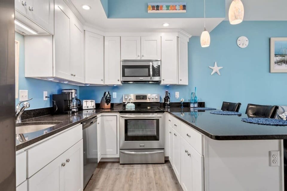 Open living room & kitchen with sleeper sofa, mounted smart TV, strong WiFi and fully-equipped kitchen