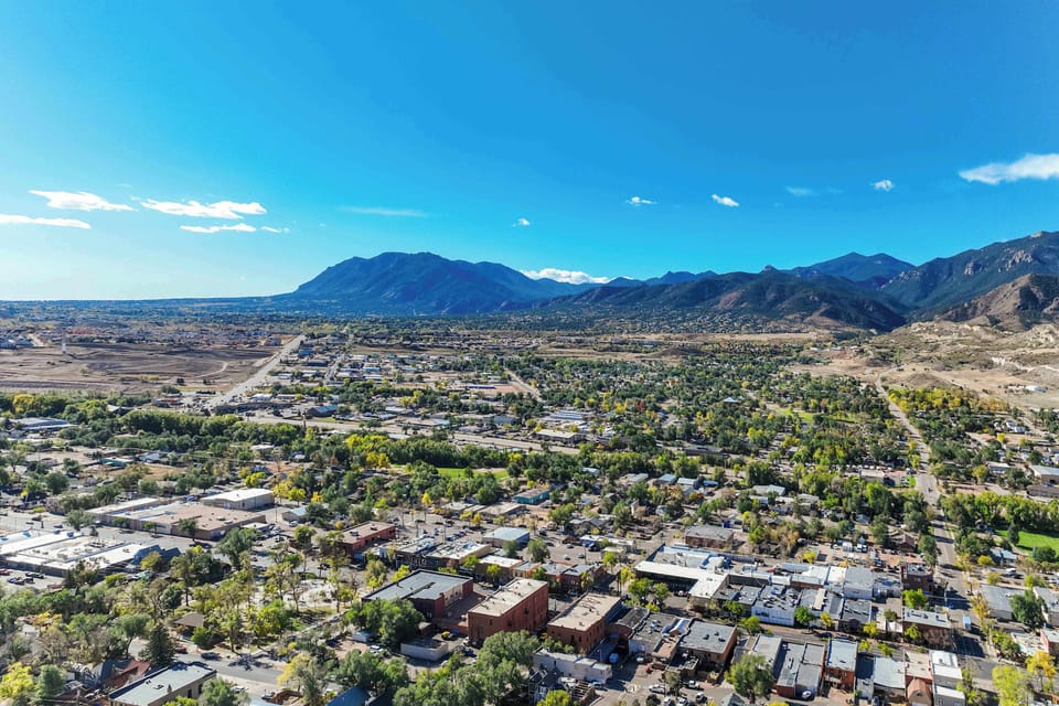 Stunning aerial view of Old Colorado City with the Rocky Mountains in the background, offering easy access to both urban attractions and outdoor adventures.