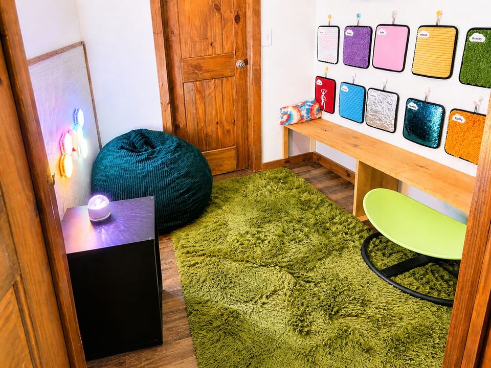 Sensory room with calming lights, textiles, and bean bag.