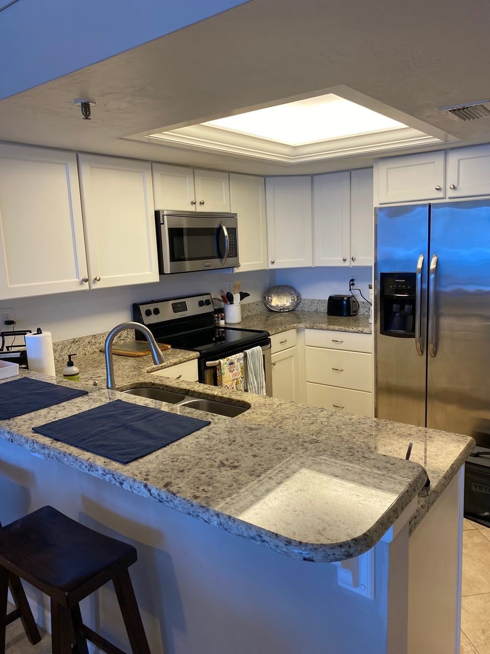 Updated kitchen with stainless steel appliances. Peninsula with two barstools.