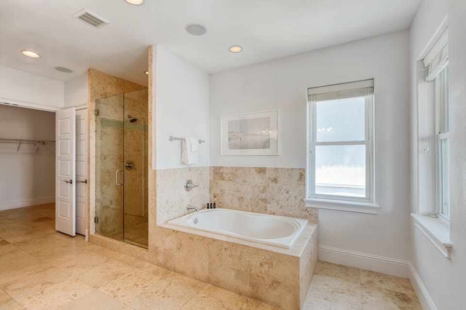 Primary bedroom's ensuite features a separate shower, a large bathtub, and double sinks.
