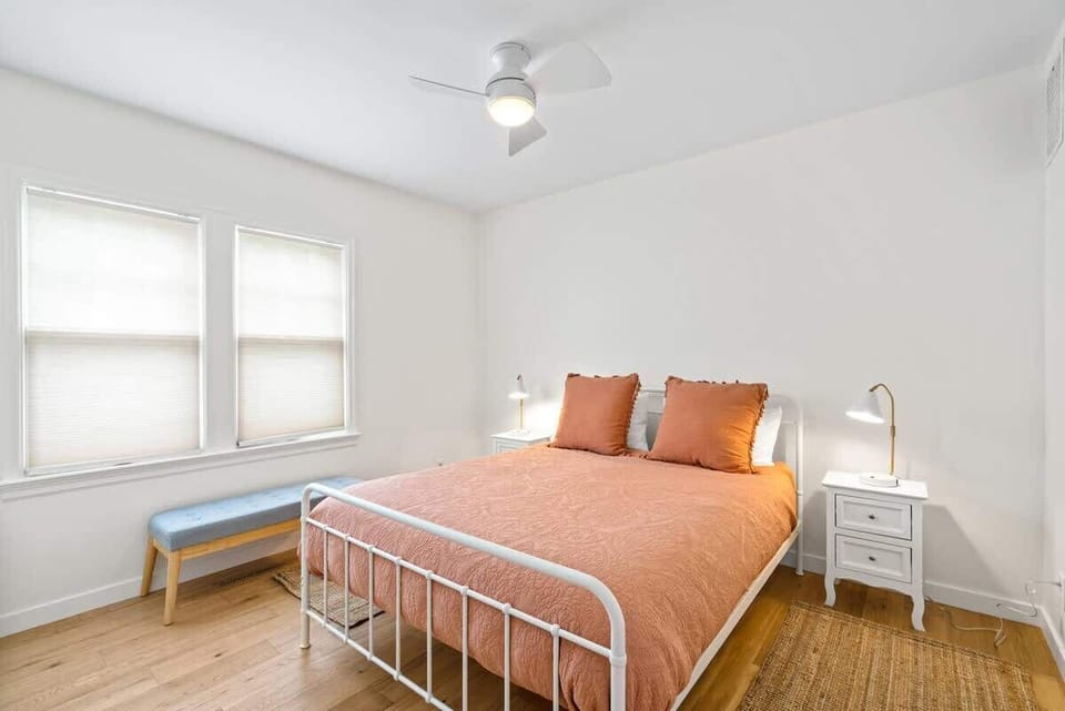 Main-floor queen bedroom featuring a comfortable bed, soft linens, ceiling fan, and a peaceful atmosphere for restful nights.