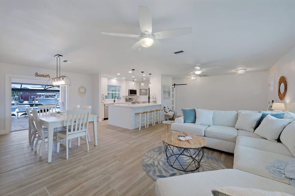 Bright open-concept living with plush sectional seating and seamless flow to the kitchen and outdoor area