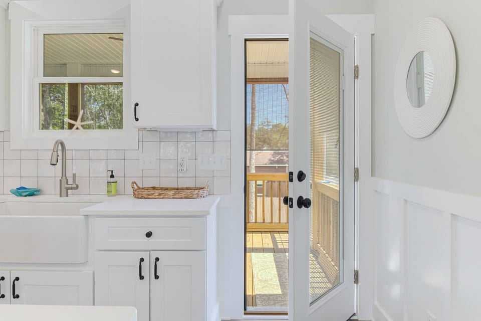 Access the large screened-in porch from the kitchen overlooking the peaceful back yard
