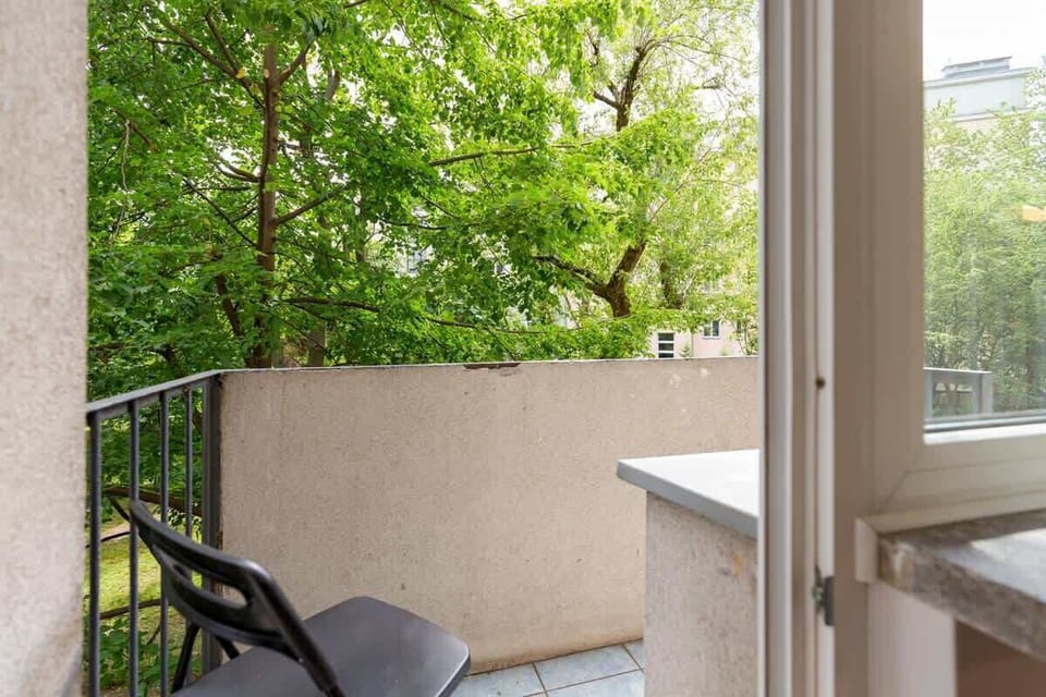 Spacious balcony with outdoor furniture. 