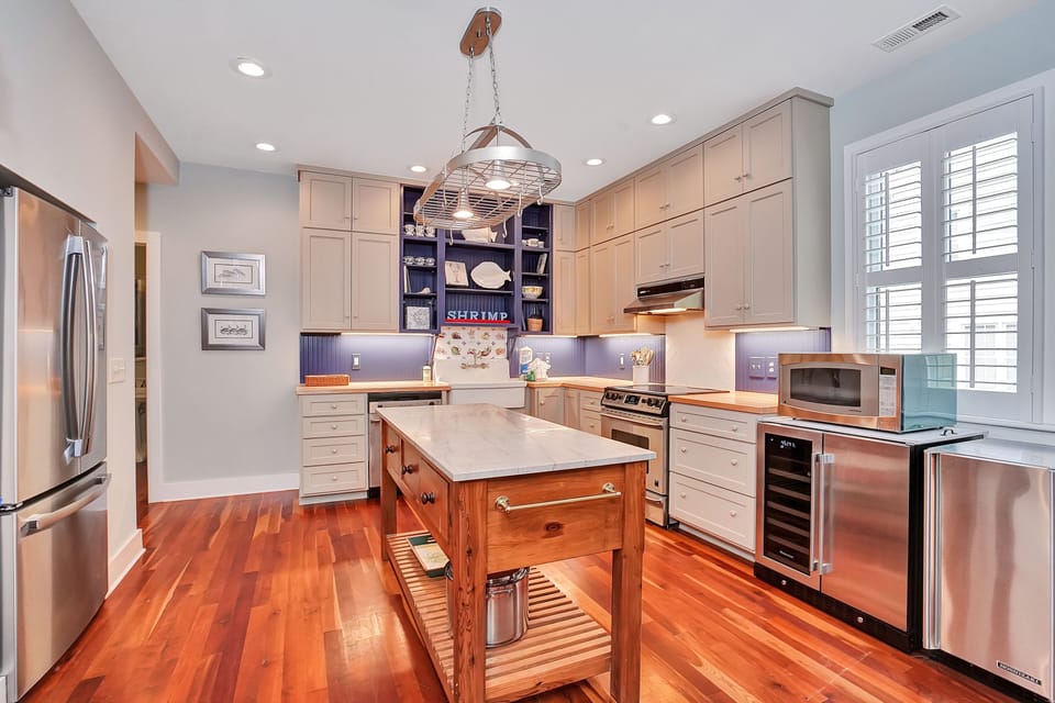 Your gourmet kitchen awaits with gleaming appliances, warm hardwood floors, and a charming island perfect for morning coffee or evening meal prep.