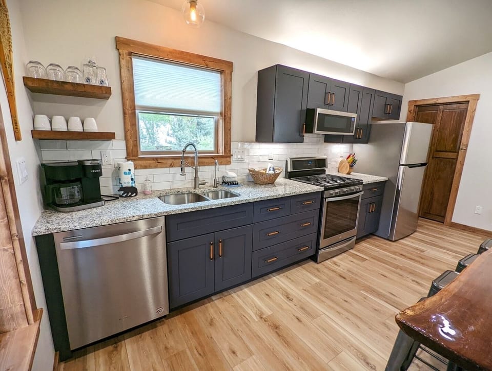 Picture yourself preparing meals in this bright, modern kitchen with sleek granite counters, stainless appliances, and charming wood accents. Everything you need to feel at home is here.