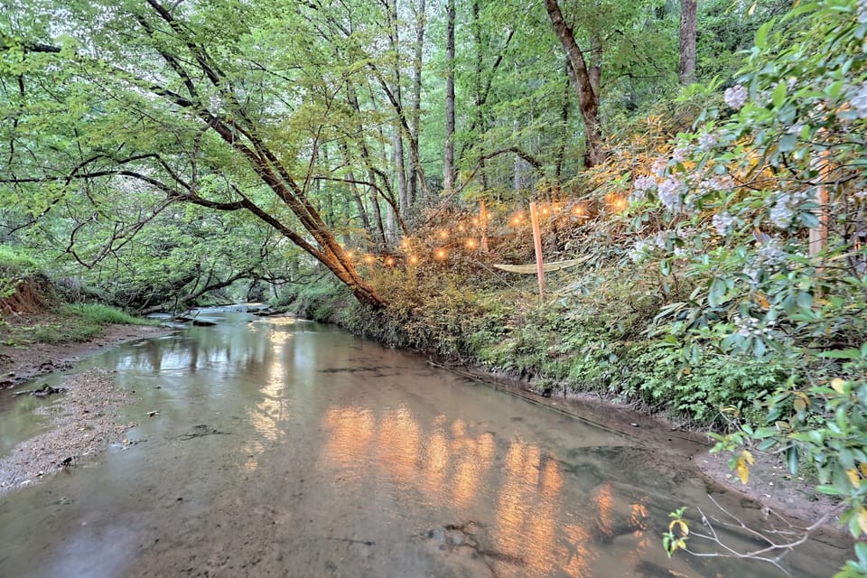 Tranquil Retreat: Enjoy evenings by the serene creek, illuminated with enchanting string lights!