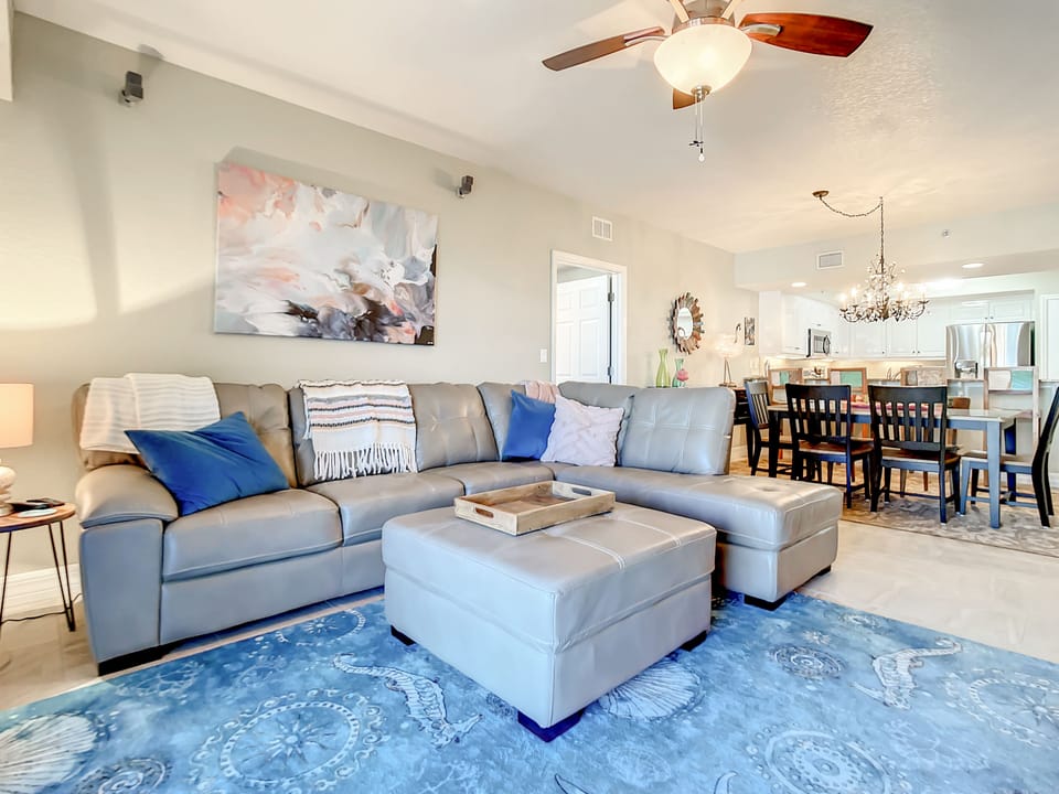 Coastal living room space with room for everyone, and access to the balcony.