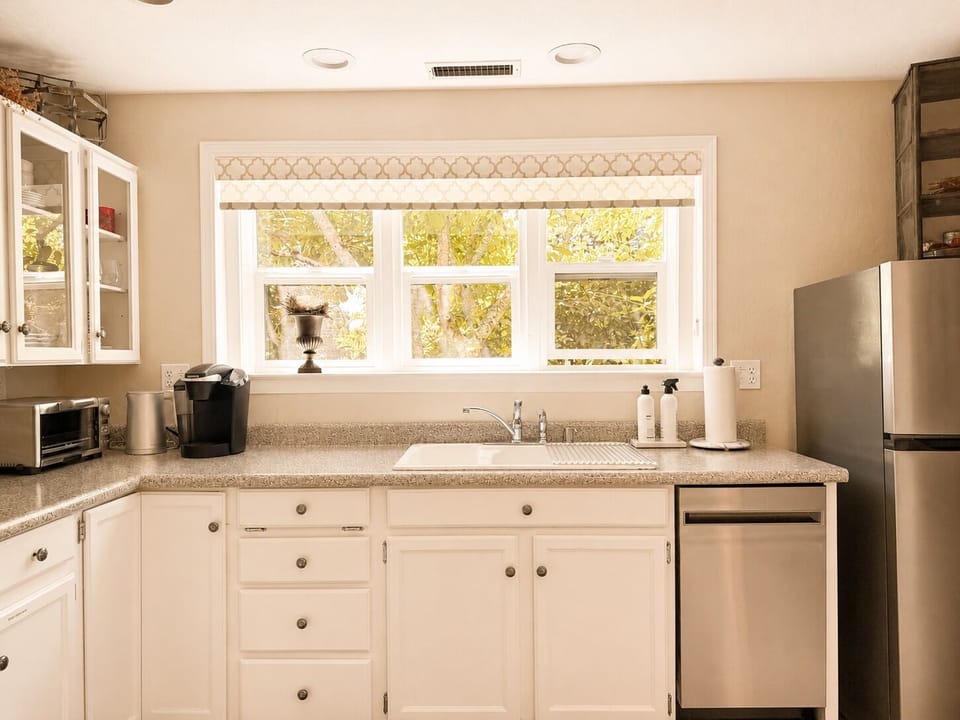 Kitchen equipped with a refrigerator, dishwasher, sink, and ample counter space