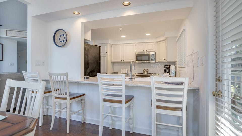 A spacious breakfast bar with seating invites casual meals and conversation, while recessed lighting keeps the space bright and welcoming.