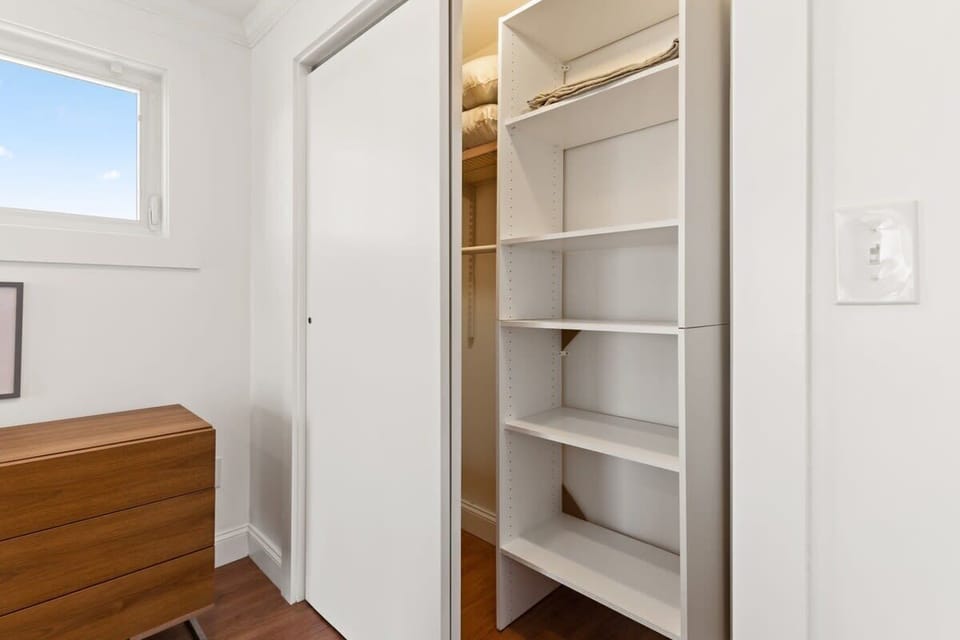 Bedroom with queen bed, sleeper sofa, work desk, smart TV and slider to private back deck