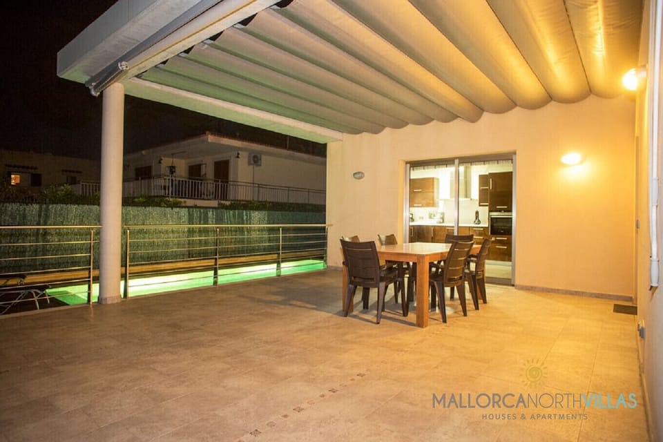 Covered terrace with outdoor dining area and direct access to the kitchen, perfect for evening meals next to the private pool at Villa Mediterranean.